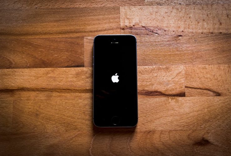 Close-up of a smartphone on a textured wooden surface, featuring a sleek design.