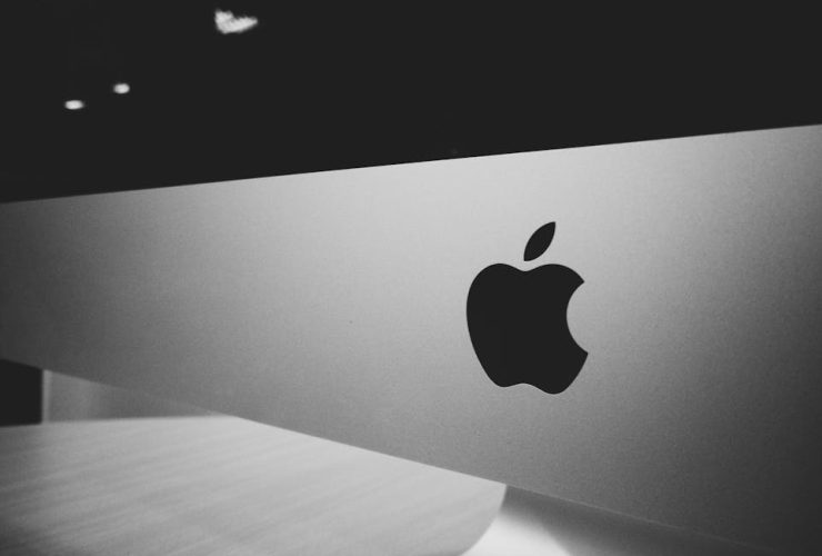 Close-up of a black and white Apple logo on a desktop screen with a modern minimalist design.
