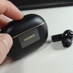 a hand holding a black box with a black logo