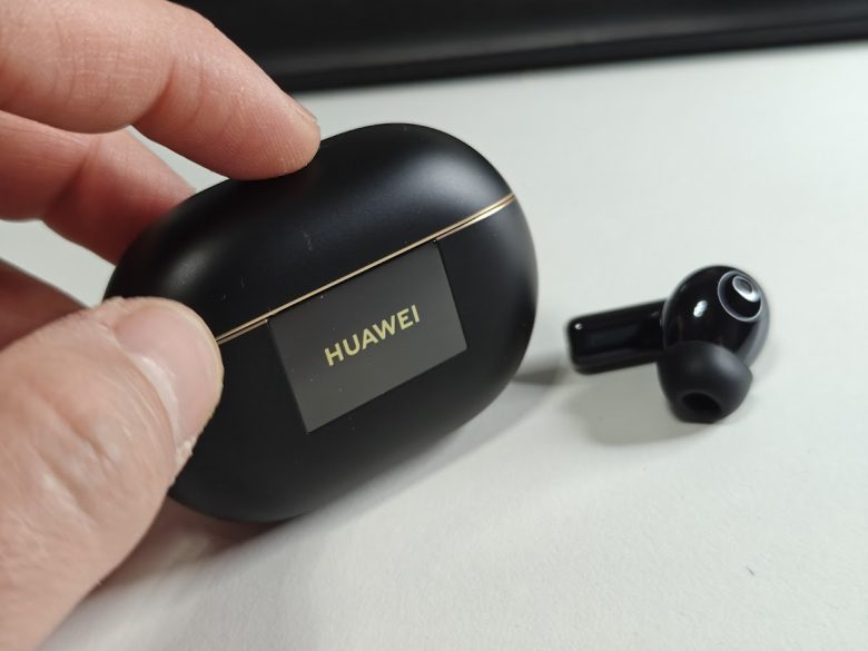 a hand holding a black box with a black logo