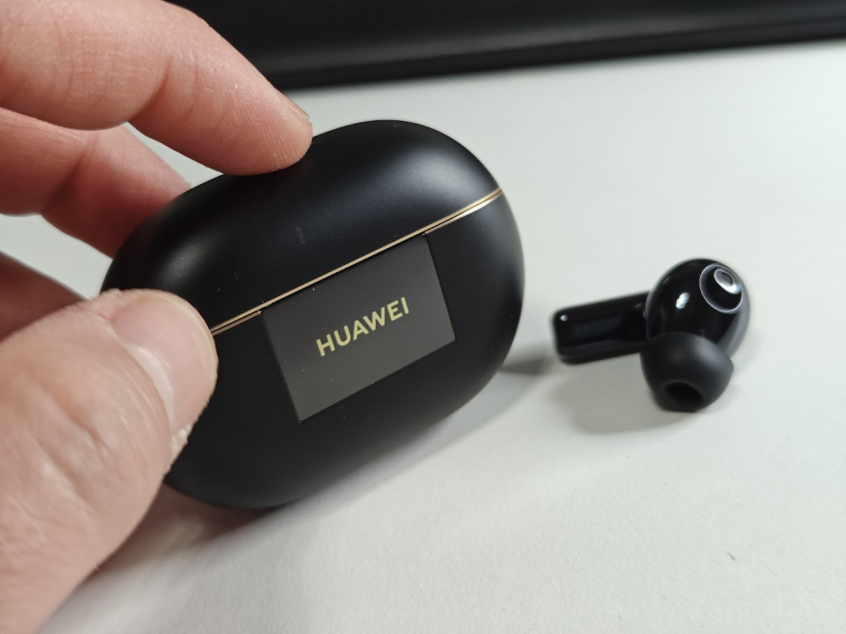 a hand holding a black box with a black logo