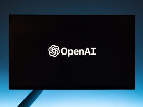 Minimalist display of OpenAI logo on a screen, set against a gradient blue background.