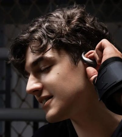 Persona che indossa gli auricolari open-ear Shokz OpenFit Air 2