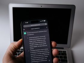 Smartphone con l'app ChatGPT accanto a un laptop