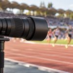 Teleobiettivo professionale a bordo pista: immagine illustrativa generata con IA, non il prodotto Nikon