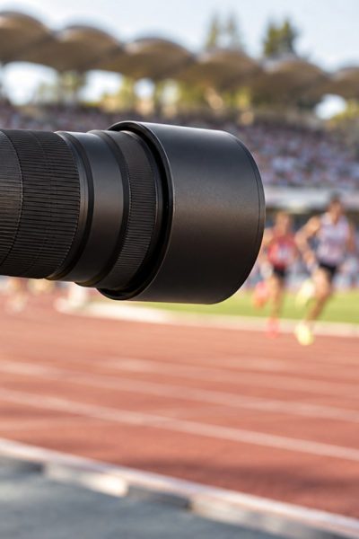 Teleobiettivo professionale a bordo pista: immagine illustrativa generata con IA, non il prodotto Nikon